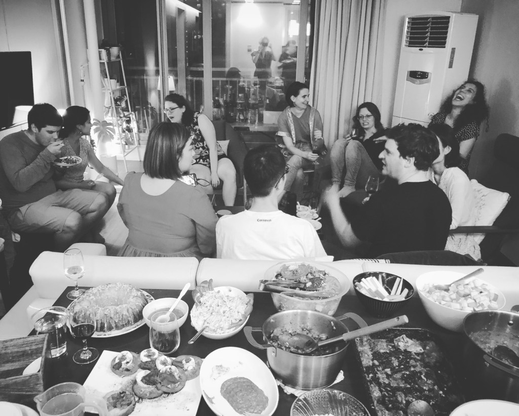 decorative image of people gathering eating, drinking, and laughing